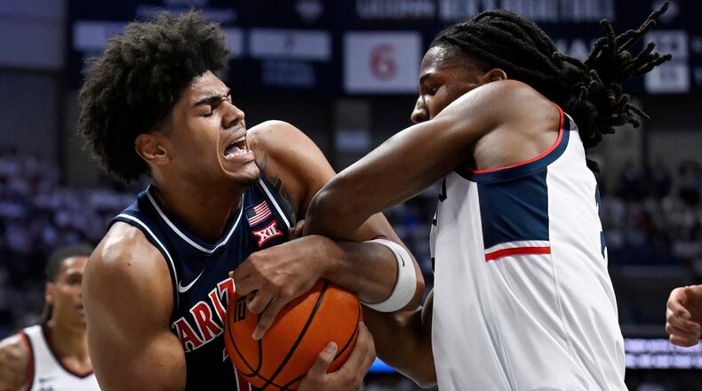 Arizona forward Koa Peat and UConn guard Silas Demary Jr., right, fight for possession of the ball in the first half of an NCAA college basketball game, Wednesday, Nov. 19, 2025, in Storrs, Conn. (AP Photo/Jessica Hill)
