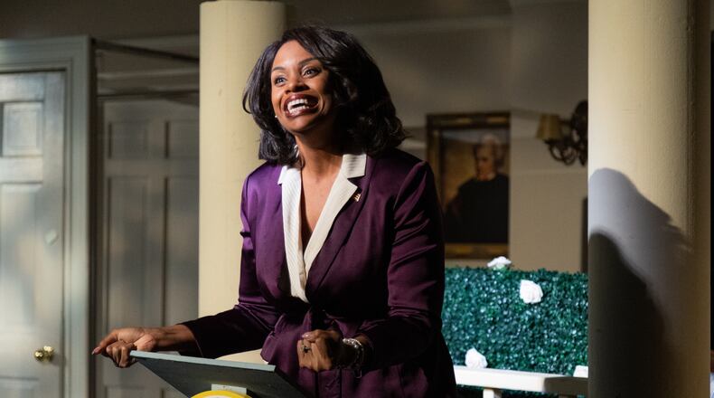 Brittani Minnieweather, clad in a power pantsuit, plays the First Lady of the United States in Sychronicity Theatre's staging of "POTUS."