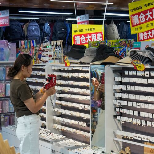 A vendor puts price tag on the ear rings for sale at her store in Beijing, China on Wednesday, July 15, 2026. (AP Photo/Andy Wong)