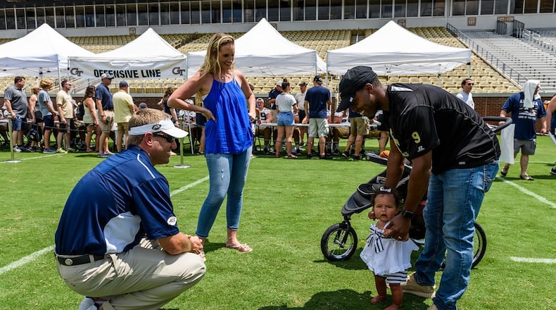 Georgia Tech quarterbacks/B-backs coach Craig Candeto (left) meets former Yellow Jackets A-back Tony Zenon's daughter Skyla (right), as Zenon and his wife, Abby, (center) looks on. They were taking part in Tech's Fan Day on Aug. 12, 2017 at Bobby Dodd Stadium. -- Danny Karnik/GT Athletics