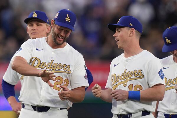 Los Angeles Dodgers' Clayton Kershaw and Will Smith show each other their rings during a World Series Champion ring ceremony prior to a baseball game against the Detroit Tigers, Friday, March 28, 2025, in Los Angeles. (AP Photo/Mark J. Terrill)