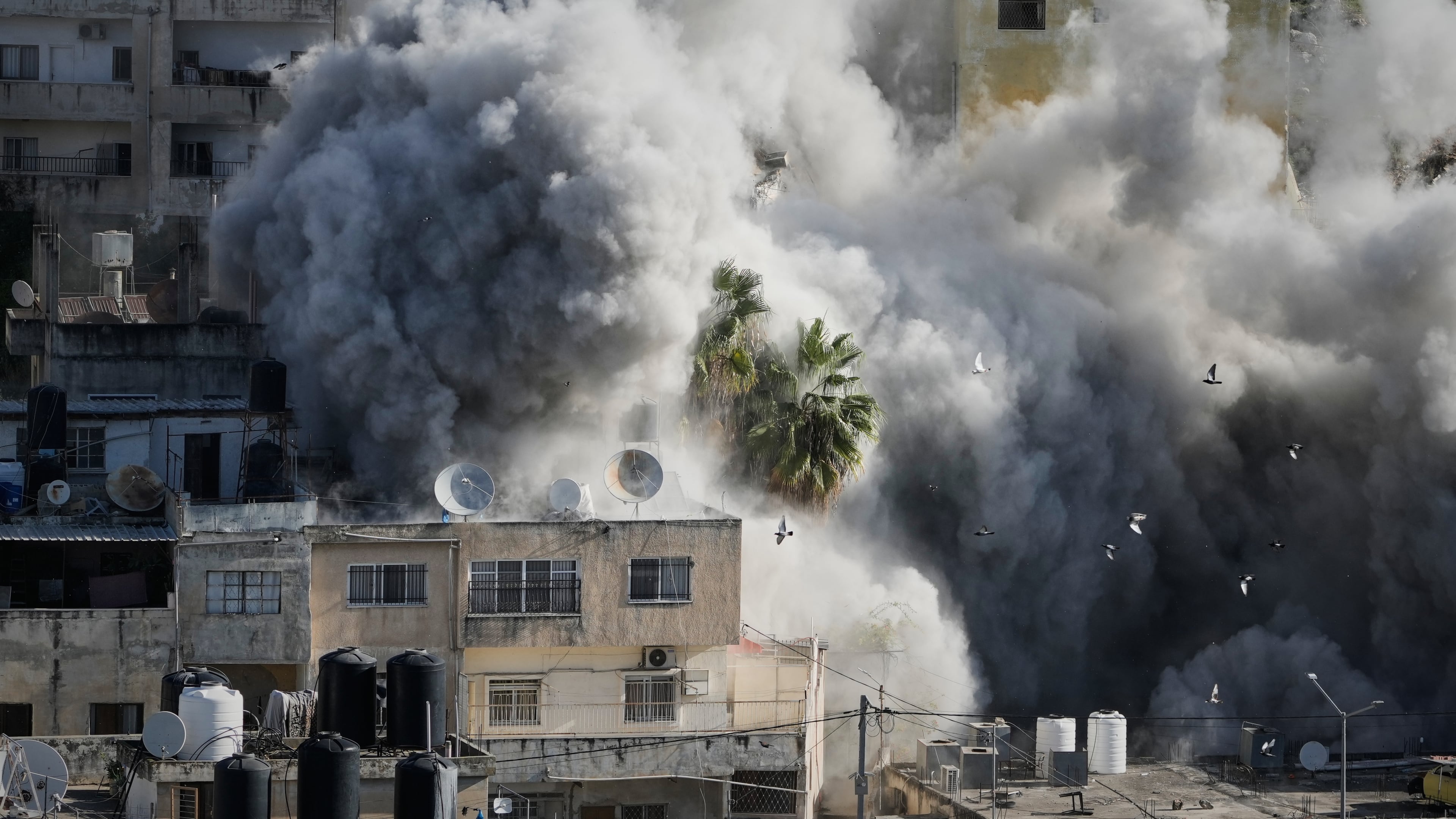 Smoke rises as Israeli forces demolish the home of Abdul Karim Sanoubar, a suspected Palestinian militant who has been accused by Israel of planting bombs on buses in central Israel, in Nablus, West Bank, Tuesday, Dec. 2, 2025. (AP Photo/Majdi Mohammed)