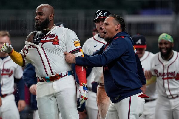 Atlanta Braves designated hitter Marcell Ozuna (20) celebrates with the team after he hit a walk-off two-run homer against the Philadelphia Phillies in the 11th inning of a baseball game after a rain delay, Friday, April 11, 2025, in Atlanta. (AP Photo/Mike Stewart)