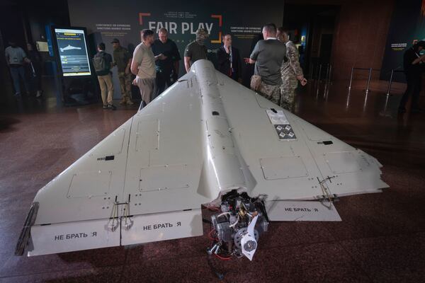 Visitors look at a damaged Iranian-made drone, Shahed, during the International Conference on Expanding Sanctions Against Russia in Kyiv, Ukraine, Friday, June 27, 2025. (AP Photo/Efrem Lukatsky)