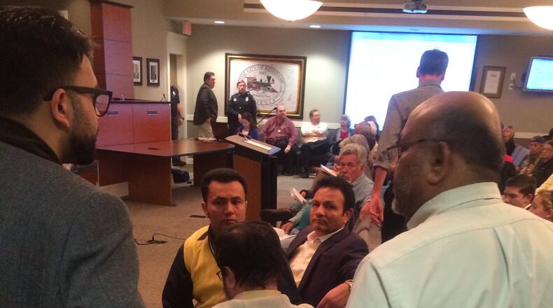 Dr. Nayyer Islam (center) and other mosque supporters gather as their attorneys conferred with city officials on Monday night.