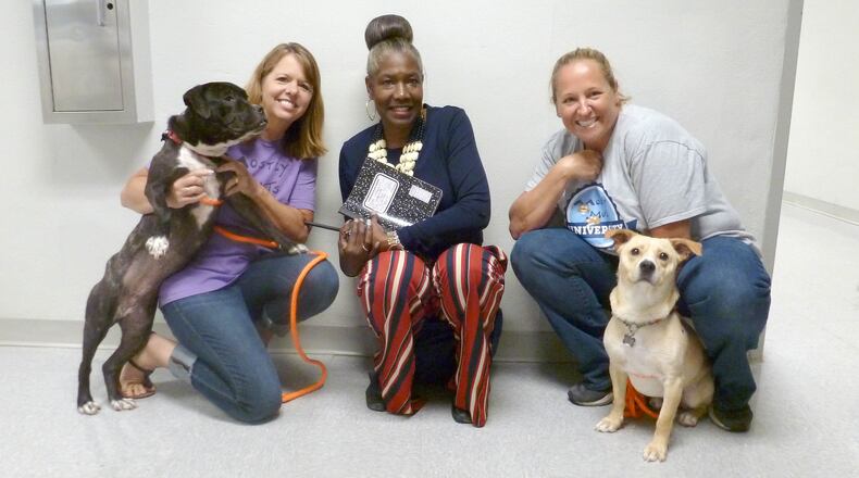 From left to right are Tammy Turley, Brenda Williams and Emily Shervin pose with Amaya and Wagner, two dogs that recently graduated from the Mostly Mutts University prison program.