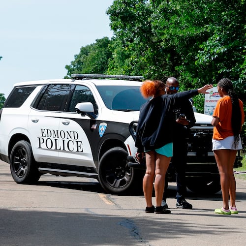 Two women talk to an Edmond police officer blocking the entrance to Scissortail Campground at Arcadia Lake, Monday, May 4, 2026, in Edmond, Okla., after a shooting on Sunday evening. (AP Photo/Alonzo Adams)