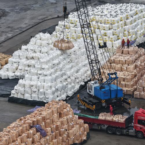 Workers transfer bags of imported solid sulfur onto a truck in a port in Nanjing in eastern China's Jiangsu province, Tuesday, April 14, 2026. (Chinatopix Via AP) CHINA OUT