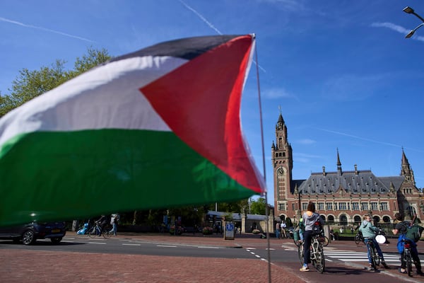 A Palestinian flag flies outside the International Court of Justice, rear, which opened hearings into a United Nations request for an advisory opinion on Israel's obligations to allow humanitarian assistance in Gaza and the West Bank, in The Hague, Netherlands, Monday, April 28, 2025. (AP Photo/Peter Dejong)