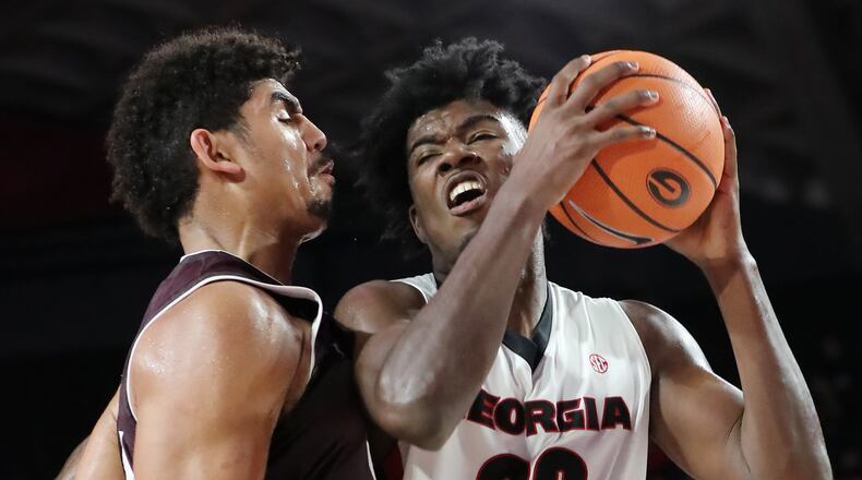 Georgia forward Rayshaun Hammonds (right) collides with Texas A&M center Tyler Davis. Curtis Compton/ccompton@ajc.com