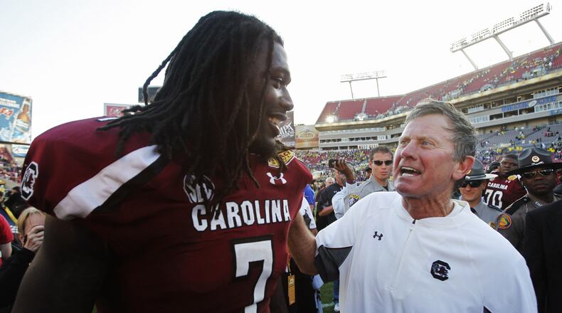 South Carolina coach Steve Spurrier (right) was right to congratulate Gamecocks defensive end Jadeveon Clowney after their win in the Outback Bowl; Clowney’s hit that knocked a Michigan player’s helmet off his head was the best play of the year, Cedric Golden writes.