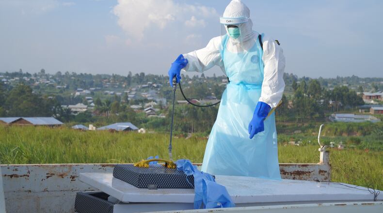 A health worker sprays the coffin containing the remains of Jacques Lobo Dhena, who died of Ebola, during a burial service in Bunia, Ituri province, eastern Congo, Wednesday, Aug. 12, 2026. (AP Photo/Dieudonne Dirole)