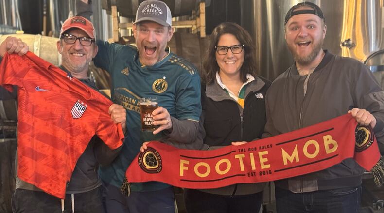 Employees at Wild Heaven Beer, a sponsor of Atlanta United and members of the unofficial Footie Mob that supports soccer in Atlanta, celebrate the announcement that Atlanta will host eight games of the 2026 Wold Cup. The are, from the left Brian Deutsch, Nick Purdy, Emily Markette and Davis Roberts. Photo: Wild Heaven