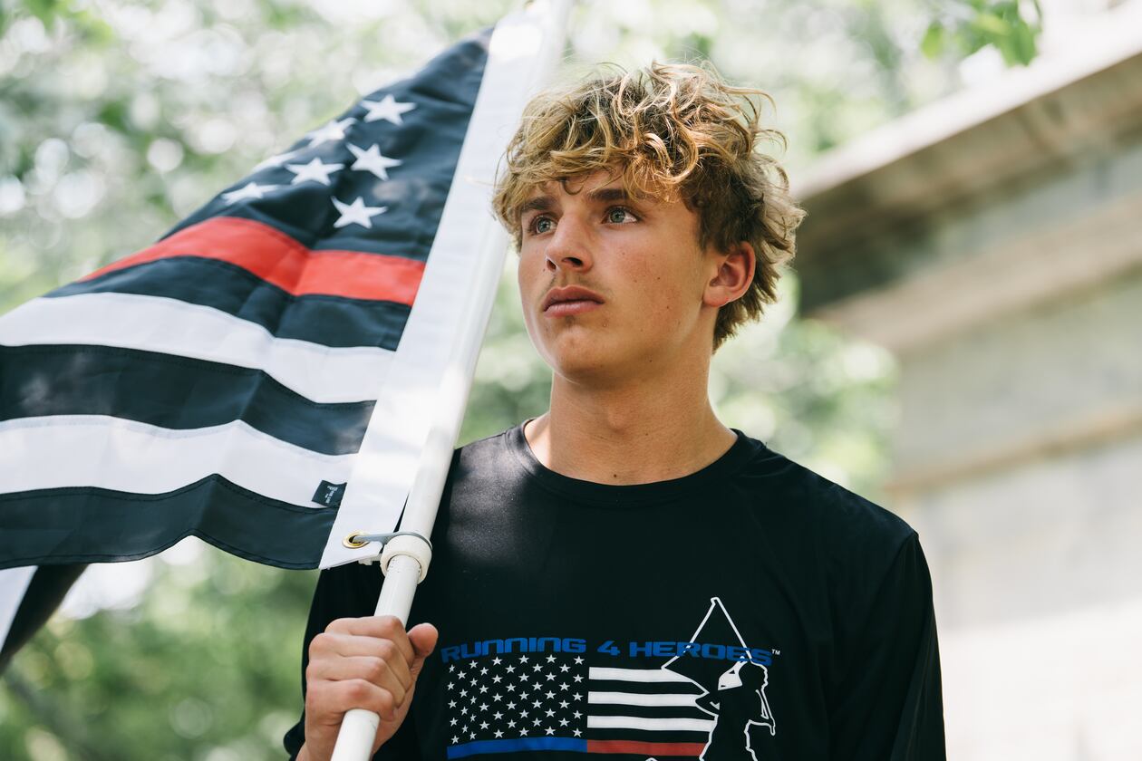Andrew Collinson, 16, poses for a portrait in the Gainesville Square July 30, 2026, the day before he undertakes his final run for the nonprofit Running 4 Heroes Inc. Collinson has run over 130 miles for the organization, honoring first responders whose lives have been lost in service (Olivia Bowdoin for the AJC).