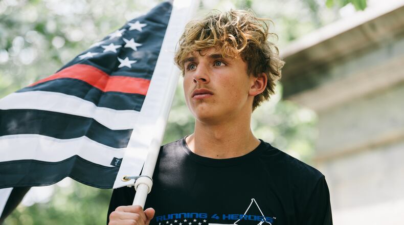 Andrew Collinson, 16, poses for a portrait in the Gainesville Square July 30, 2026, the day before he undertakes his final run for the nonprofit Running 4 Heroes Inc. Collinson has run over 130 miles for the organization, honoring first responders whose lives have been lost in service (Olivia Bowdoin for the AJC).