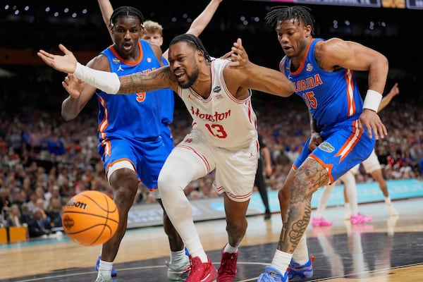 Houston's J'Wan Roberts (13) loses the ball as Florida's Alijah Martin (15) and Rueben Chinyelu (9) defend during the second half in the national championship at the Final Four of the NCAA college basketball tournament, Monday, April 7, 2025, in San Antonio. (AP Photo/Eric Gay)