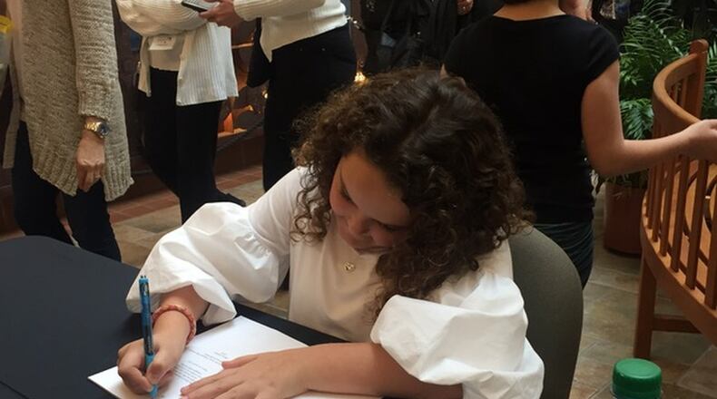 Dylan Dickson signs copies of her book, “Why Can’t I Read?” during a recent event. CONTRIBUTED