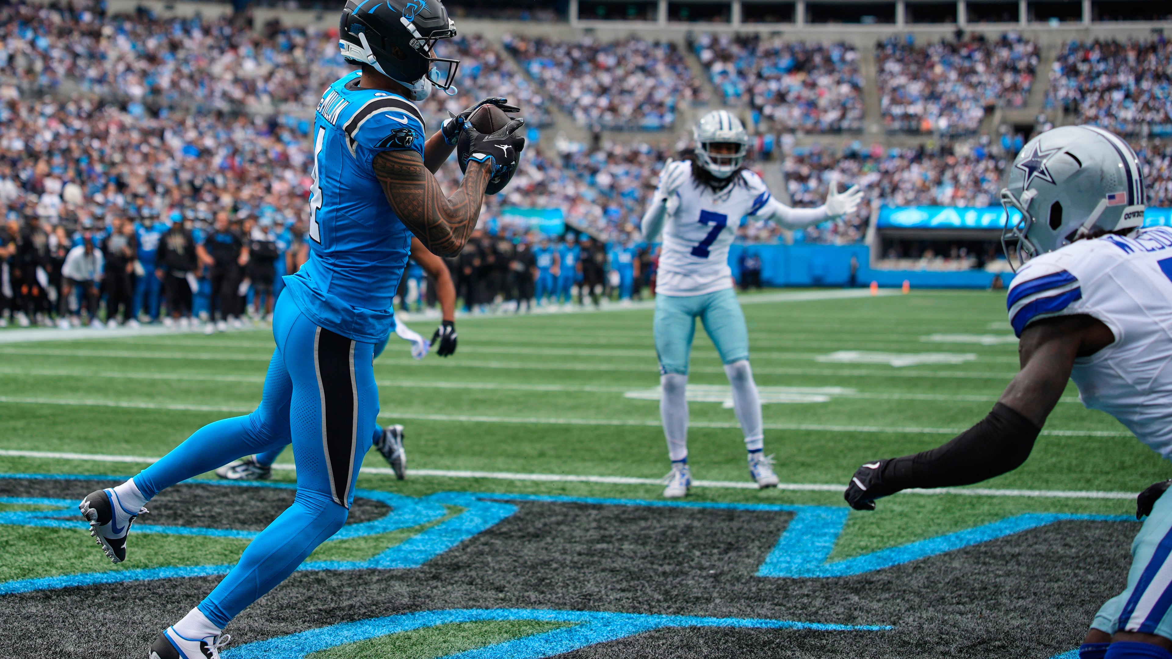 Carolina Panthers wide receiver Tetairoa McMillan (4) catches a touchdown pass in front of Dallas Cowboys' Trevon Diggs (7) and Donovan Wilson, right, in the second half of an NFL football game, Sunday, Oct. 12, 2025, in Charlotte, N.C. (AP Photo/Jacob Kupferman)