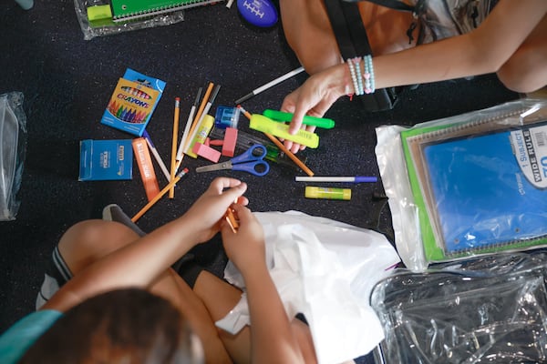 Hapeville Elementary fourth grade students go through the contents of their new backpacks at the Delta Flight Museum in Atlanta during the Stuff the Plane school supply drive.  (Natrice Miller/AJC 2023)