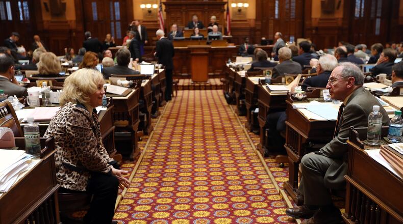 Reps. Lynn Smith (R-Newnan) and Brooks Coleman (R-Duluth) talk across the aisle Tuesday evening March 18, 2014, as the next to last day of the regular Legislative session stretches into the evening. BEN GRAY / BGRAY@AJC.COM