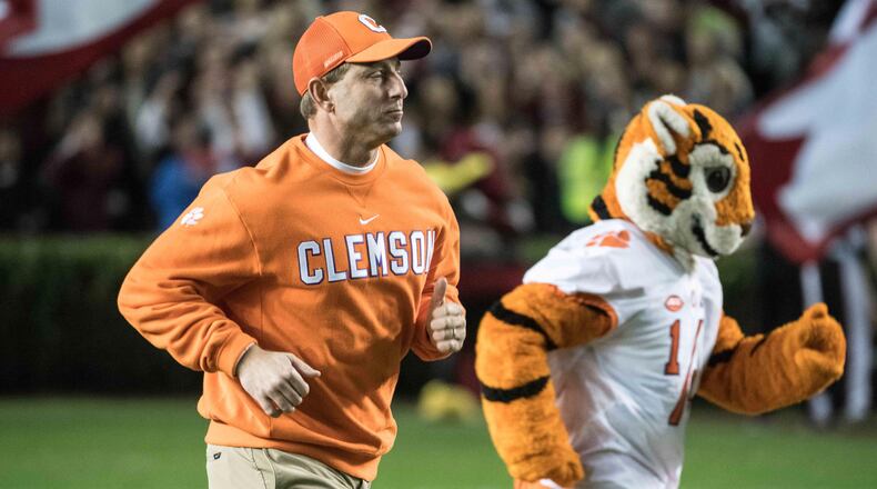 Clemson head coach Dabo Swinney runs onto the field  with one of his friends before last week's victory over rival South Carolina. (AP Photo/Sean Rayford)