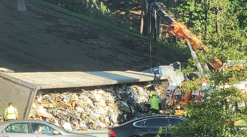 A tractor-trailer hauling trash overturned and blocked lanes on the I-285 East ramp to I-75 North early Tuesday morning.