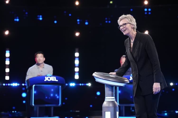 Jane Lynch (right) hosts as Joel Kim Booster competes on Fox’s “Celebrity Weakest Link.” The trivia game show is the latest in an array of primetime game shows coming to metro Atlanta. (Greg Gayne/Fox 2025)