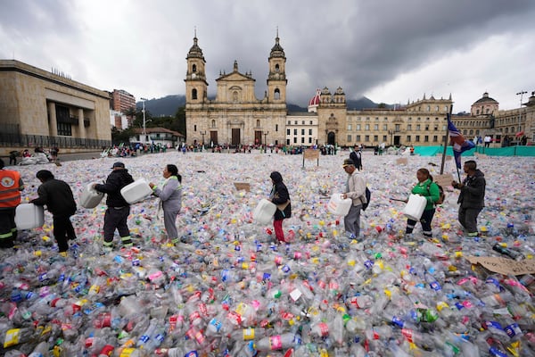 Recyclers wade through plastic bottles blanketing Plaza Bolivar in Bogota, Colombia, as they protest against what recyclers consider to be too low a price paid to them by companies that buy recycled materials, Tuesday, June 24, 2025. (AP Photo/Fernando Vergara)