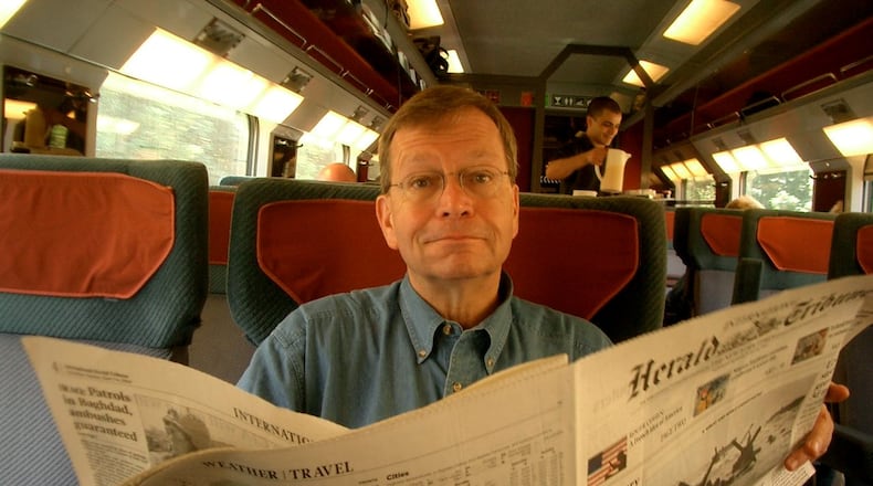 Dick Williams in 2004 in London with a newspaper, a medium he always loved. Williams was a fixture in Atlanta journalism for decades. CONTRIBUTED