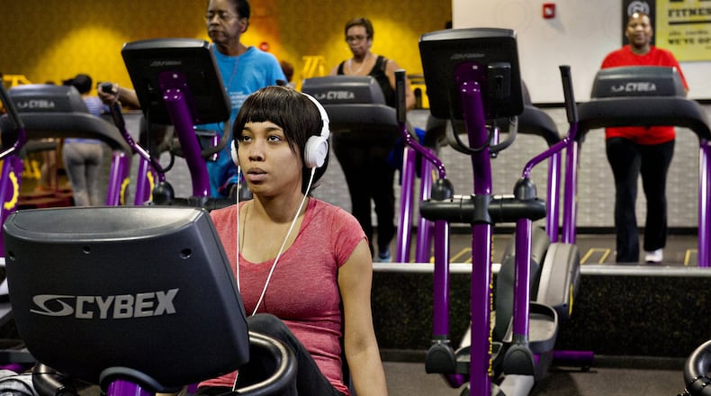 In this file photo, Rachel Butler uses a stationary bike as she and others work out at a Planet Fitness in Decatur.