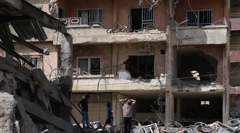 Residents inspect damage at the site of buildings destroyed in Israeli airstrikes, in Jibchit, southern Lebanon, Friday, April 17, 2026, following a ceasefire between Israel and Hezbollah. (AP Photo/Hassan Ammar)