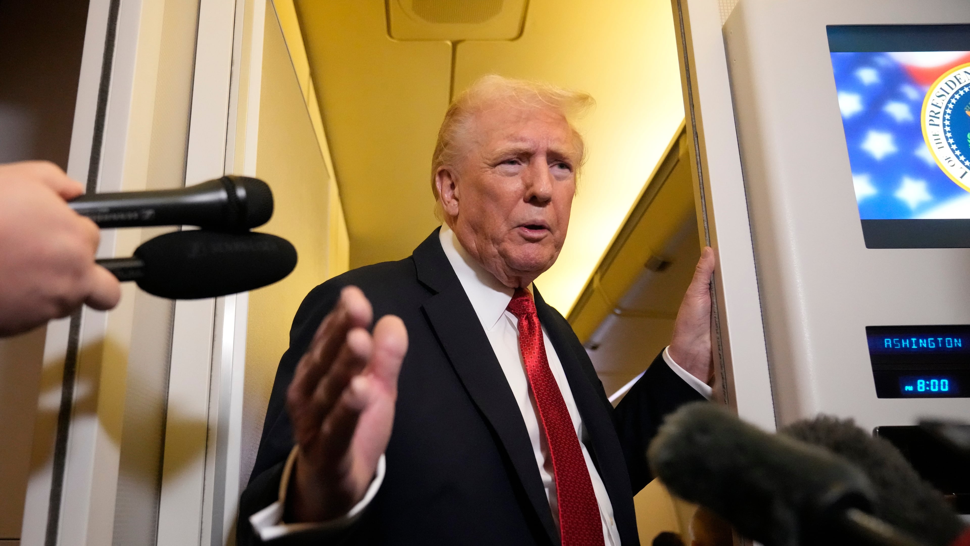 President Donald Trump speaks to reporters aboard Air Force One, Sunday, Oct. 19, 2025, en route to Joint Base Andrews, Md., as he returns from a trip to Florida. (AP Photo/Mark Schiefelbein)