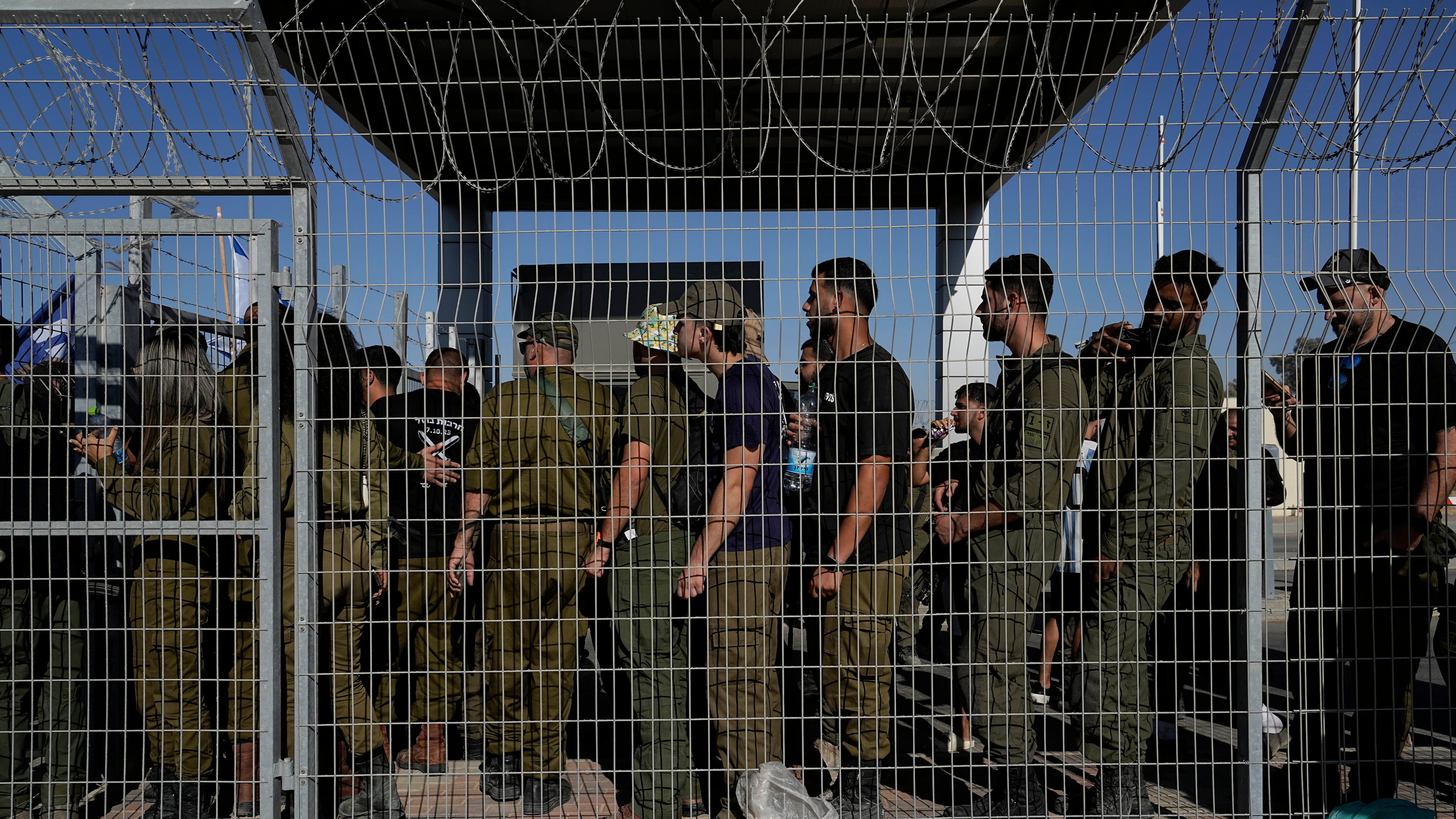 FILE - Israeli soldiers gather at the gate to the Sde Teiman military base, as people protest in support of soldiers being questioned for detainee abuse, July 29, 2024. (AP Photo/Tsafrir Abayov, File)