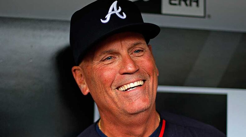 Brian Snitker smiles while talking to reporters in the dugout before Tuesday's game.