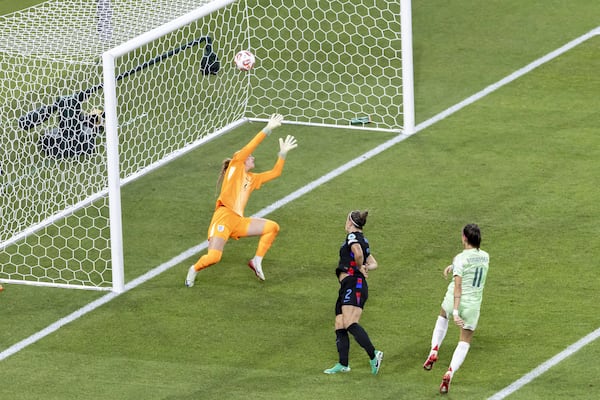 Italy's Barbara Bonansea, right, scores the opening goal past England's goalkeeper Hannah Hampton during the Women's Euro 2025 semifinals soccer match between England and Italy at Stade de Geneve in Geneva, Switzerland, Tuesday, July 22, 2025. (Salvatore Di Nolfi/Keystone via AP)