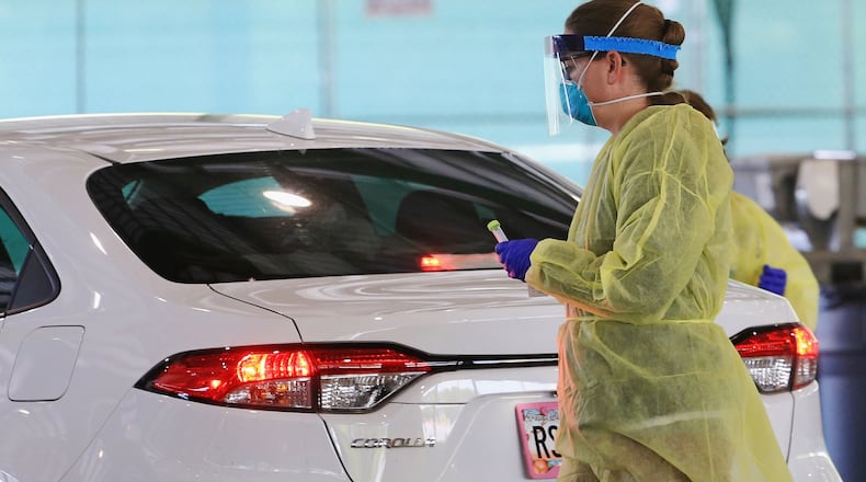 A healthcare worker tests people for COVID-19 in Marietta on Friday, April 17, 2020. (Christina Matacotta, for The Atlanta Journal-Constitution)