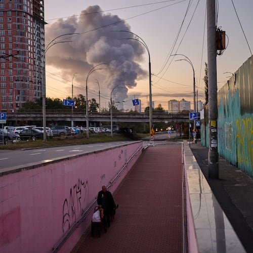 A man walks along an underpass as smoke rises following a Russian missile attack in Kyiv, Ukraine, early Tuesday, Sept. 8, 2026. (AP Photo/Francisco Seco)
