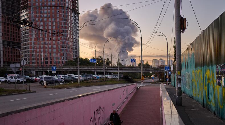 A man walks along an underpass as smoke rises following a Russian missile attack in Kyiv, Ukraine, early Tuesday, Sept. 8, 2026. (AP Photo/Francisco Seco)