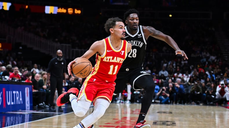 Atlanta Hawks guard Trae Young (11) drives against Brooklyn Nets forward Dorian Finney-Smith (28) during the second half of an NBA basketball game Wednesday, Dec. 6, 2023, in Atlanta. (AP Photo/Hakim Wright Sr.)