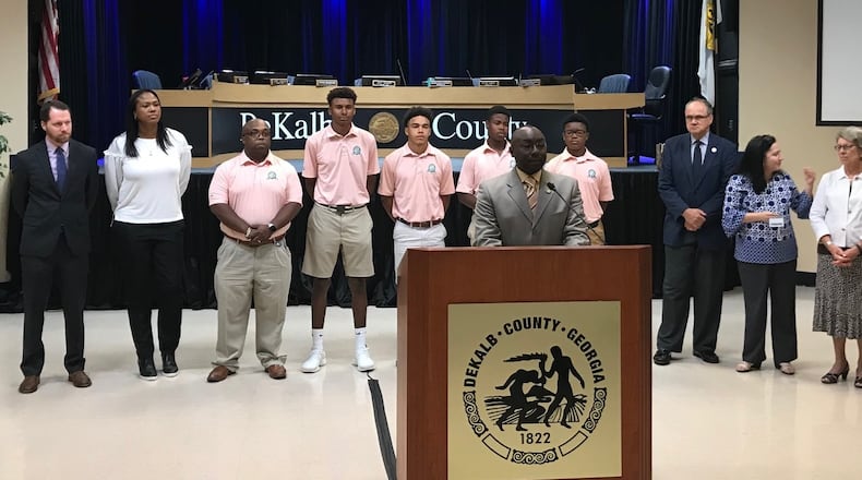 DeKalb County Commissioner Larry Johnson (center) gives remarks during a presentation honoring the members of Charles R. Drew Charter School's golf team. The team won the state championship earlier this year. The team is standing with their coaches and other members of the DeKalb Board of Commissioners. (TIA MITCHELL/TIA.MITCHELL@AJC.COM)