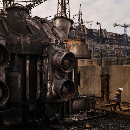 FILE - A worker walks in front of a transformer which was destroyed after a recent Russian missile attack at DTEK's power plant in Ukraine, Nov. 28, 2024. (AP Photo/Evgeniy Maloletka, file)