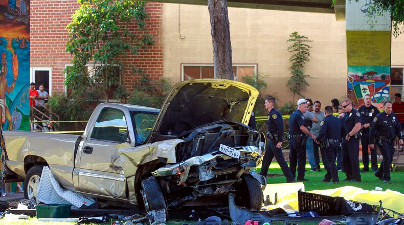 Police stand near the pickup truck that landed at Chicano Park after it flew off a ramp to the San Diego Coronado Bridge in San Diego on Saturday, Oct. 15, 2016. Four people were killed and nine were injured on Saturday after an out-of-control pickup truck plunged off the San Diego-Coronado Bridge and plowed into crowd gathered at a festival below, authorities said. (Hayne Palmour IV/The San Diego Union-Tribune via AP)