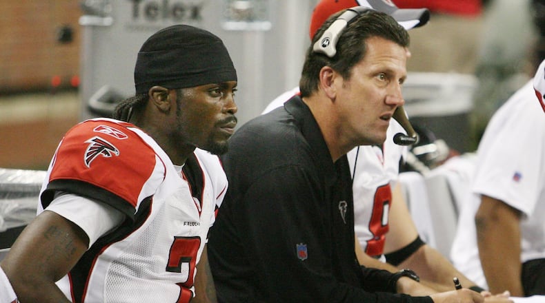 Falcons QB Michael Vick and offensive coordinator Greg Knapp sit on the bench in 2006. (CURTIS COMPTON / AJC staff)