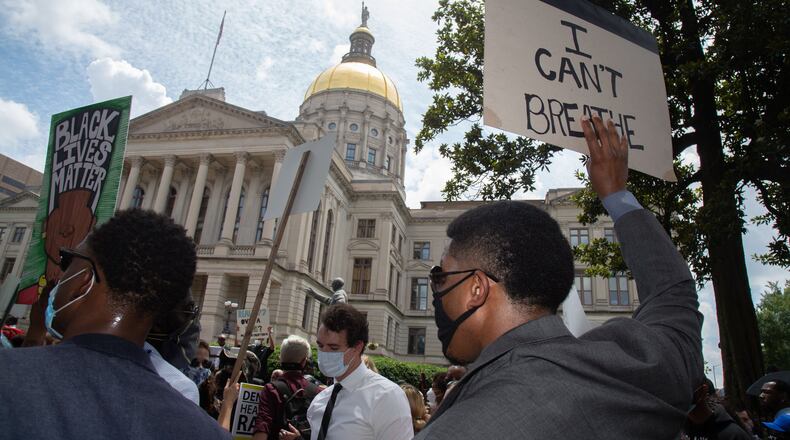 Marchers hold up signs in front of the State Capitol during a march in honor of George Floyd’s Funeral Thursday, June 4, 2020. STEVE SCHAEFER FOR THE ATLANTA JOURNAL-CONSTITUTION