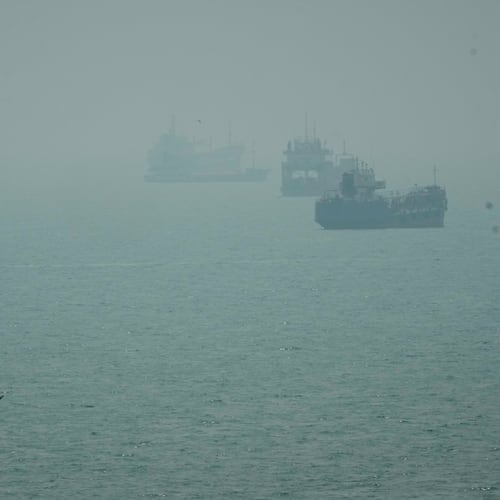 A motorboat travels past commercial vessels anchored amid haze in the Strait of Hormuz off Bandar Abbas, Iran, Monday, Sept. 7, 2026. (AP Photo/Vahid Salemi)