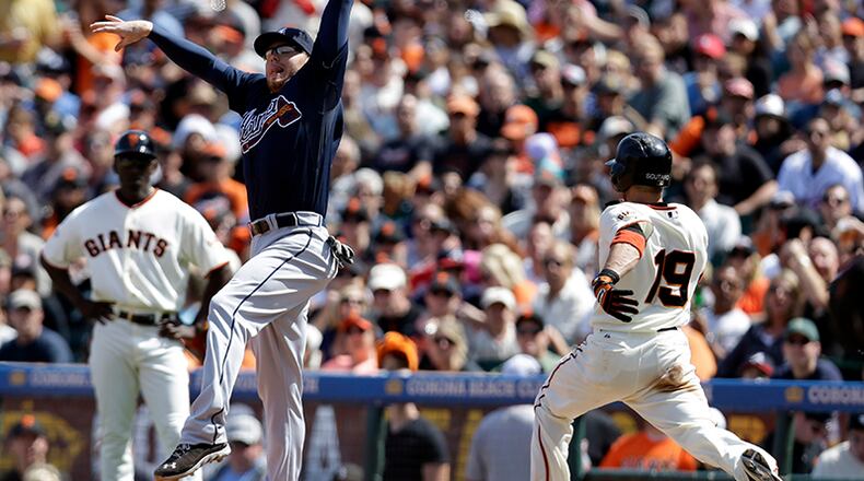 Braves first baseman Freddie Freeman reaches up to catch a high throw to put out San Francisco Giants' Marco Scutaro during the seventh inning Saturday in San Francisco.