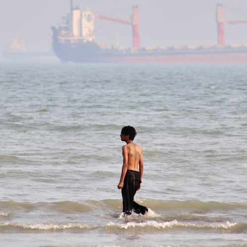 A boy walks on shallow water as commercial vessels are anchored in the Strait of Hormuz off Bandar Abbas, Iran, Monday, Aug. 31, 2026. (Razieh Poudat/ISNA via AP)