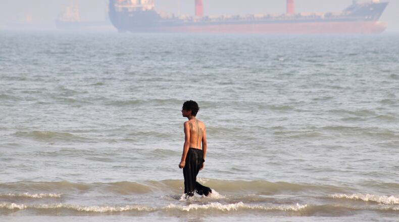 A boy walks on shallow water as commercial vessels are anchored in the Strait of Hormuz off Bandar Abbas, Iran, Monday, Aug. 31, 2026. (Razieh Poudat/ISNA via AP)