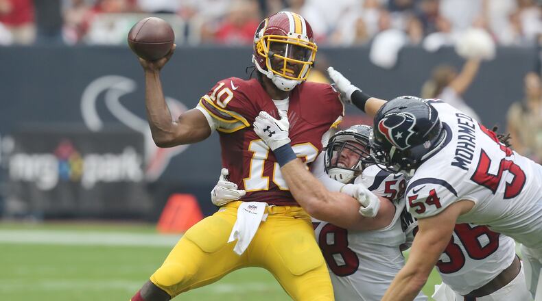 Washington Redskins quarterback Robert Griffin III #10 is sacked by Houston Texans linebacker Brooks Reed #58 and linebacker Mike Mohamed #54. (Photo by Thomas B. Shea/Getty Images)