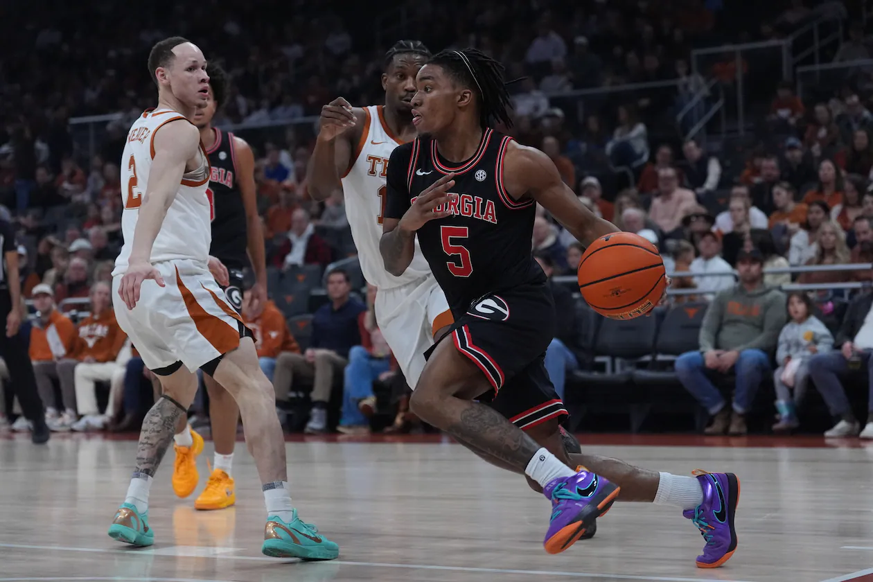 Georgia guard Jeremiah Wilkinson (right) drives around Texas guard Tramon Mark (center) during the first half Saturday, Jan. 24, 2026, in Austin, Texas. The Longhorns trailed 37-30 at halftime but beat the Bulldogs 87-67. (Eric Gay/AP)